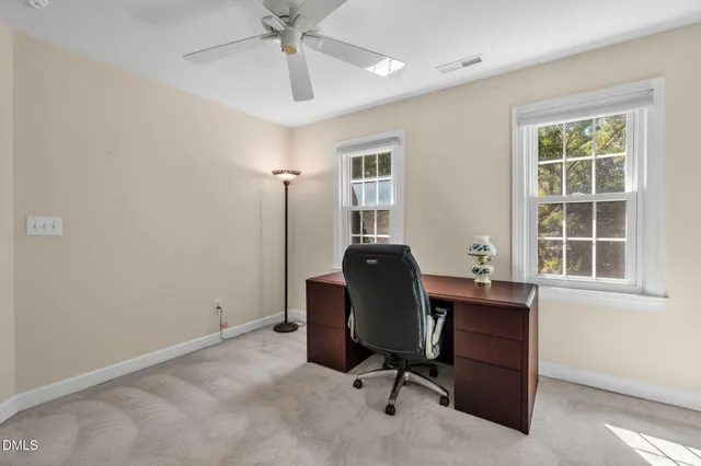 a view of a workspace with furniture and a window