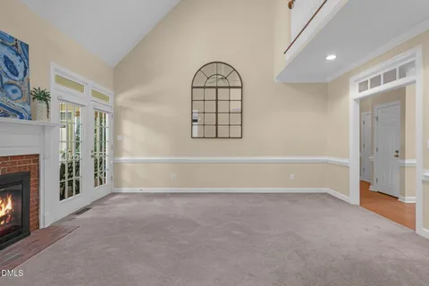an empty room with windows and fireplace