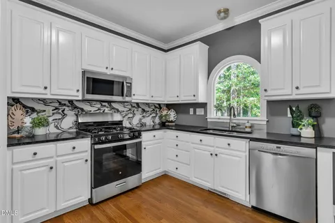 a kitchen with granite countertop white cabinets and white appliances