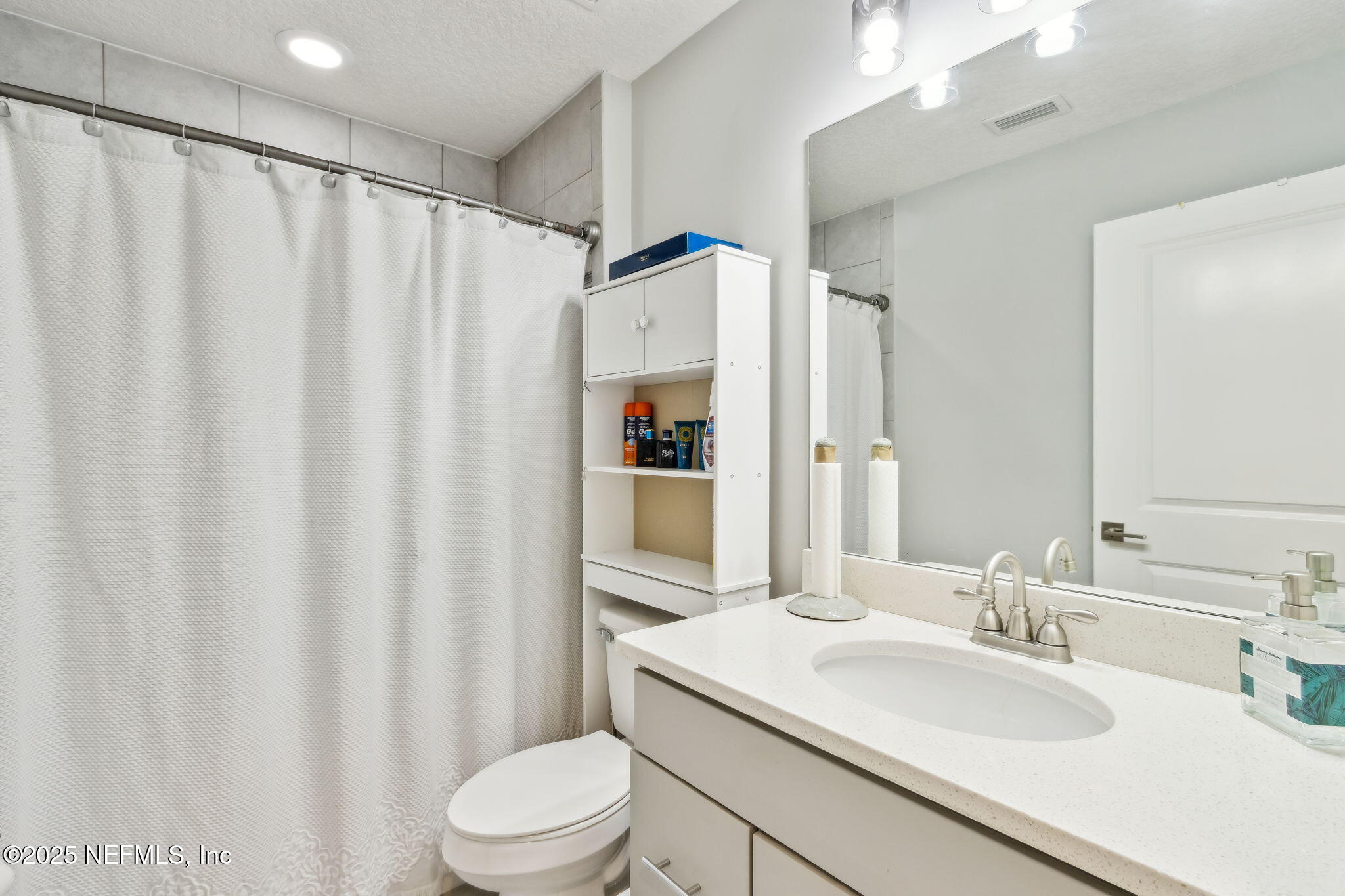 75652 Edwards Road Yulee, FL 32097 - Photo 17 of 26 a bathroom with a sink a toilet and shower curtain