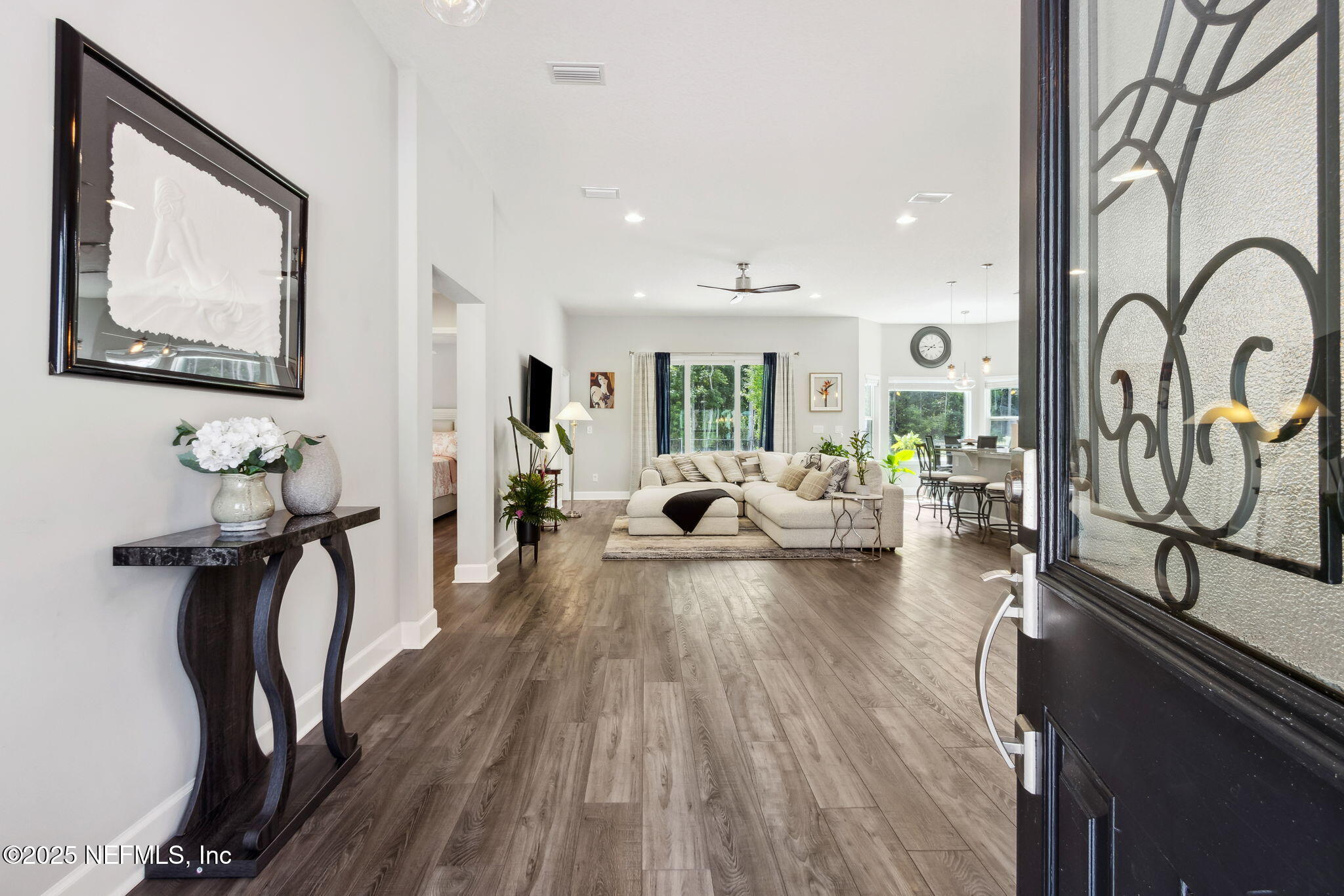 75652 Edwards Road Yulee, FL 32097 - Photo 5 of 26 a living room with furniture a rug potted plant and a painting on the wall