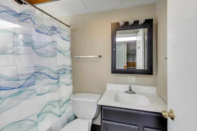 a bathroom with a sink toilet and mirror