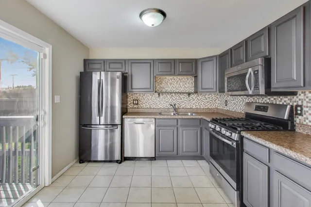 a kitchen with a stove a refrigerator and a sink