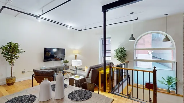 a living room with furniture a flat screen tv and a potted plant