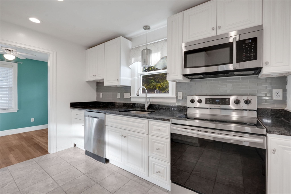 7 Longworth Road Worcester, MA 01602 - Photo 5 of 20 a kitchen with stainless steel appliances granite countertop a stove a sink and a microwave