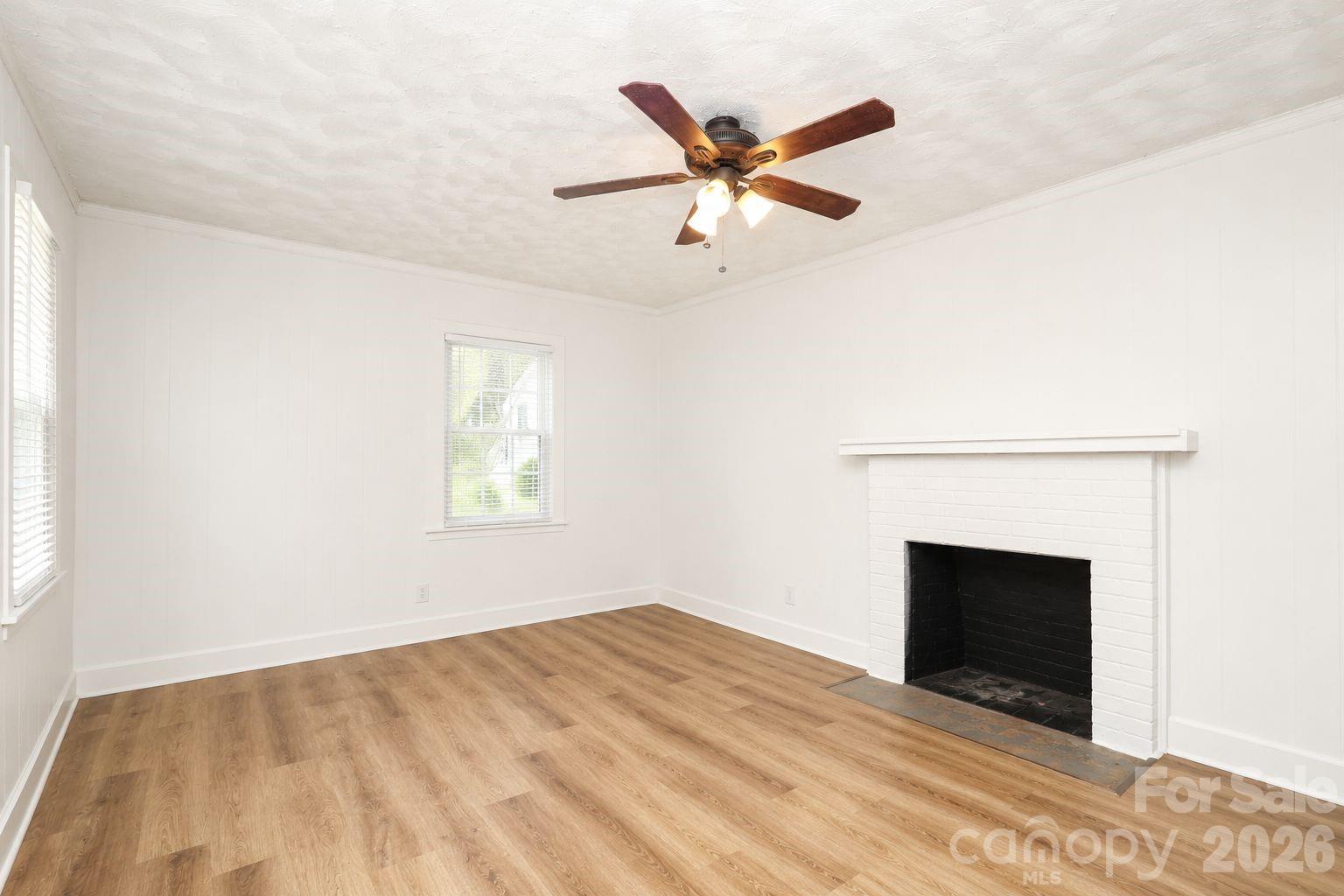 1324 State Rd S-29-496 Lancaster, SC 29720 - Photo 5 of 28 a view of an empty room with wooden floor and a fireplace