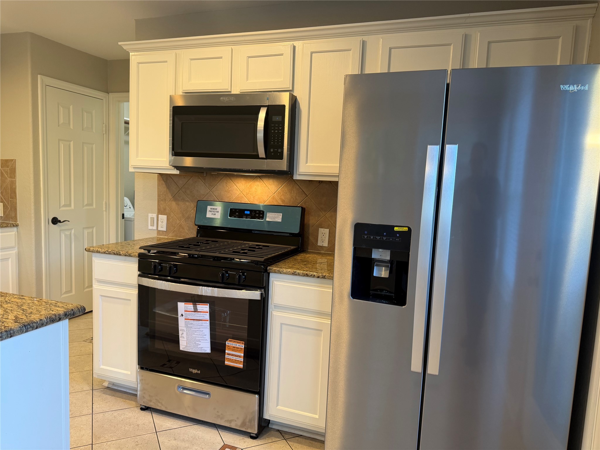 58 Shimmer Pond Place Conroe, TX 77385 - Photo 14 of 35 a kitchen with stainless steel appliances wooden cabinets and a refrigerator