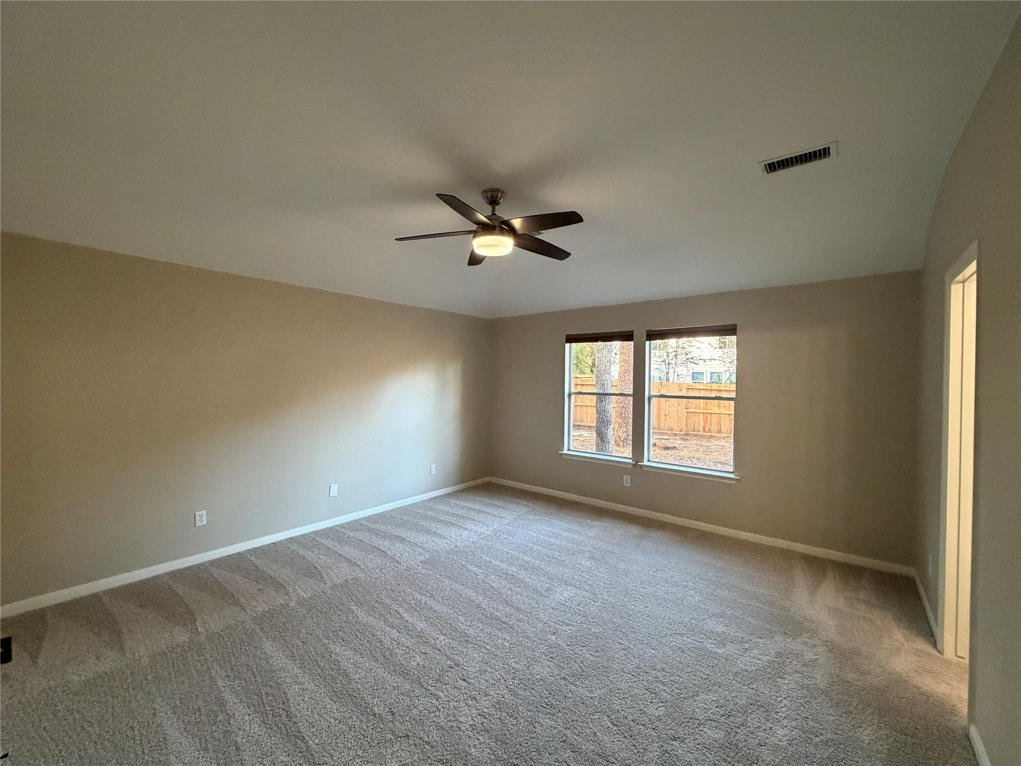 58 Shimmer Pond Place Conroe, TX 77385 - Photo 19 of 35 an empty room with a ceiling fan and window