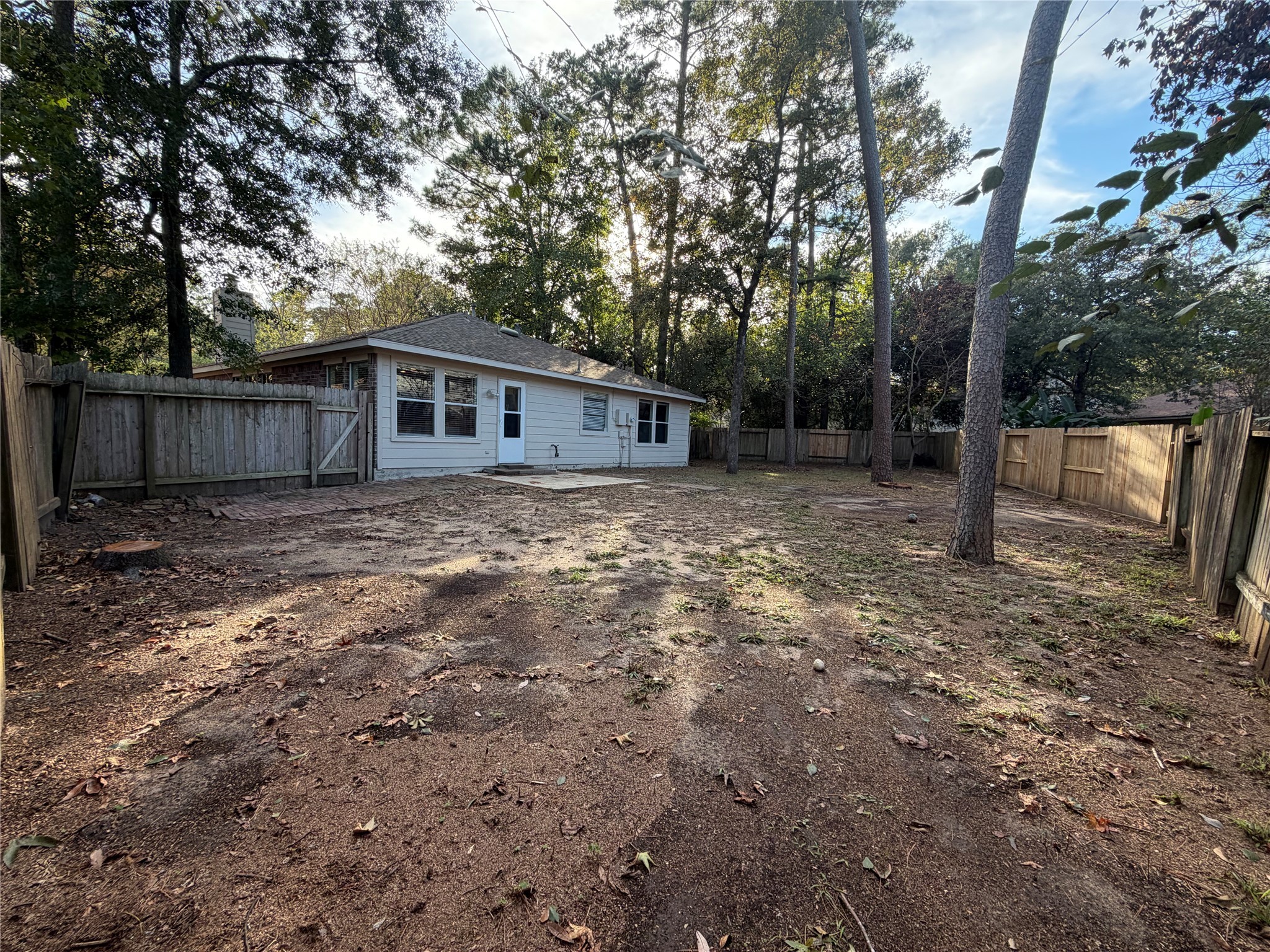 58 Shimmer Pond Place Conroe, TX 77385 - Photo 32 of 35 a view of a backyard with large trees and wooden fence
