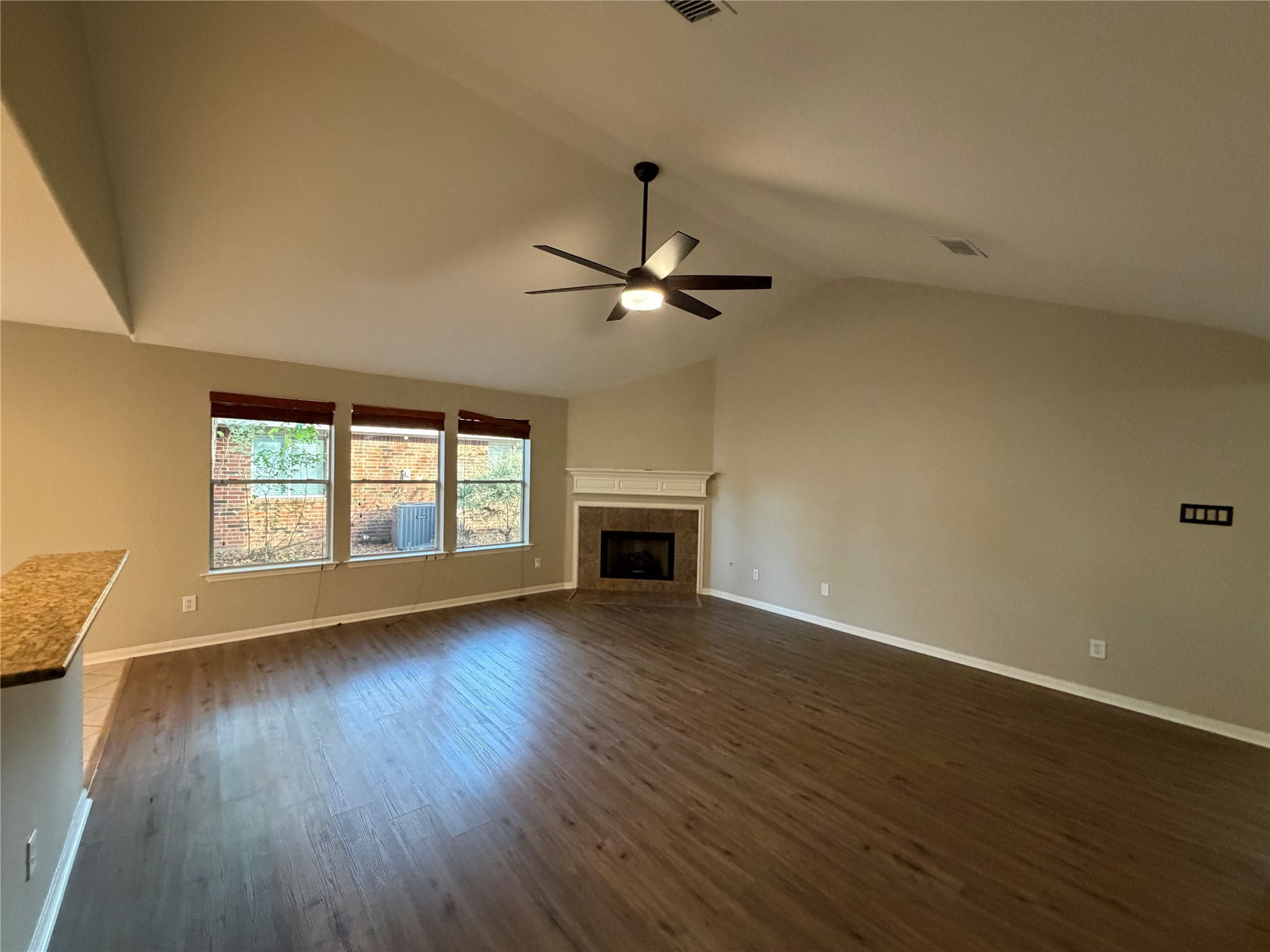 58 Shimmer Pond Place Conroe, TX 77385 - Photo 5 of 35 an empty room with wooden floor fireplace and windows