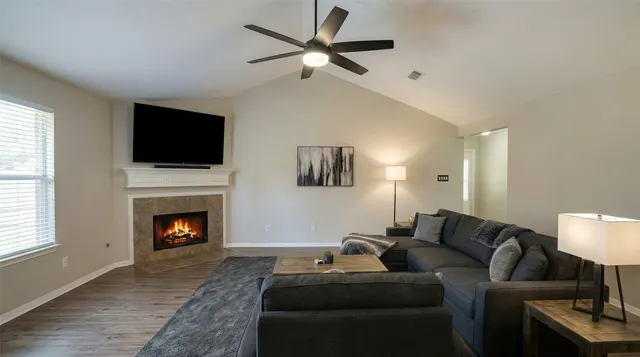 a living room with furniture a fireplace and a flat screen tv
