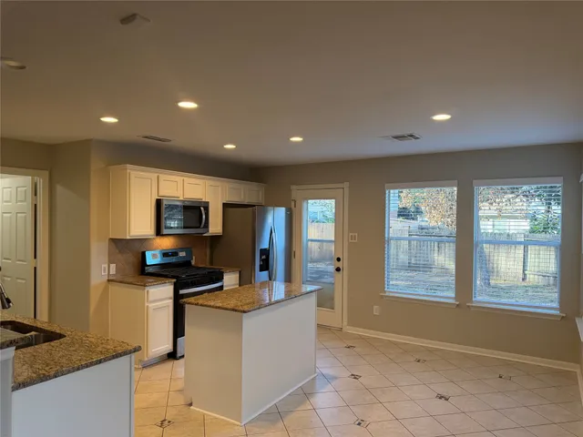 a kitchen with stainless steel appliances wooden cabinets and a refrigerator