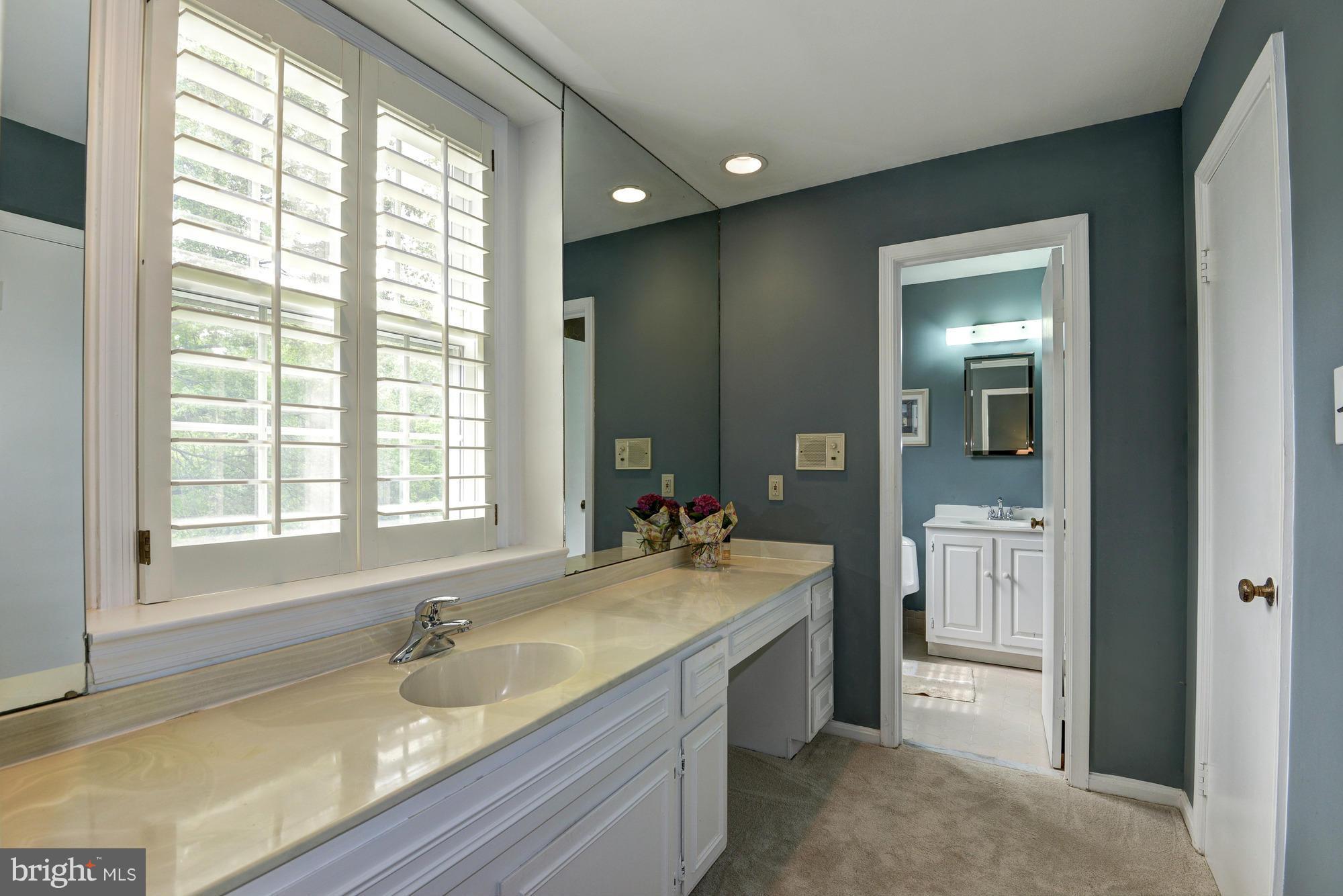 912 Kimberwicke Road McLean, VA 22102 - Photo 19 of 30 a bathroom with a granite countertop sink and a large mirror