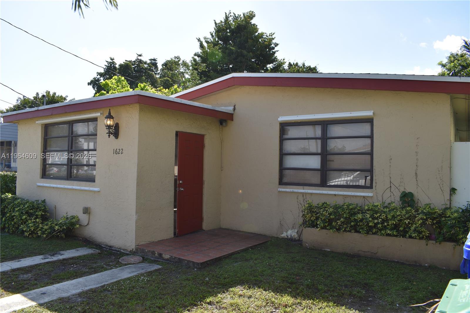 1622 Northwest 65th Street Miami, FL 33147 - Photo 1 of 6 a front view of a house with a yard