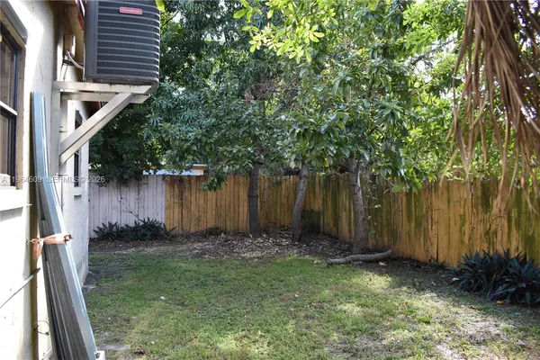 a view of backyard with green space and trees
