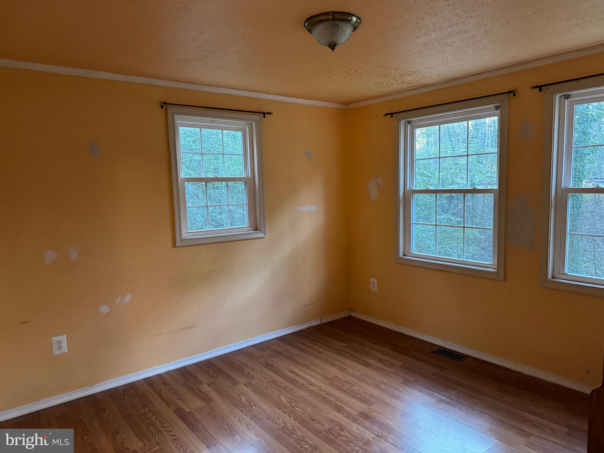 12924 Rousby Hall Road Lusby, MD 20657 - Photo 10 of 15 a view of an empty room with wooden floor and a window