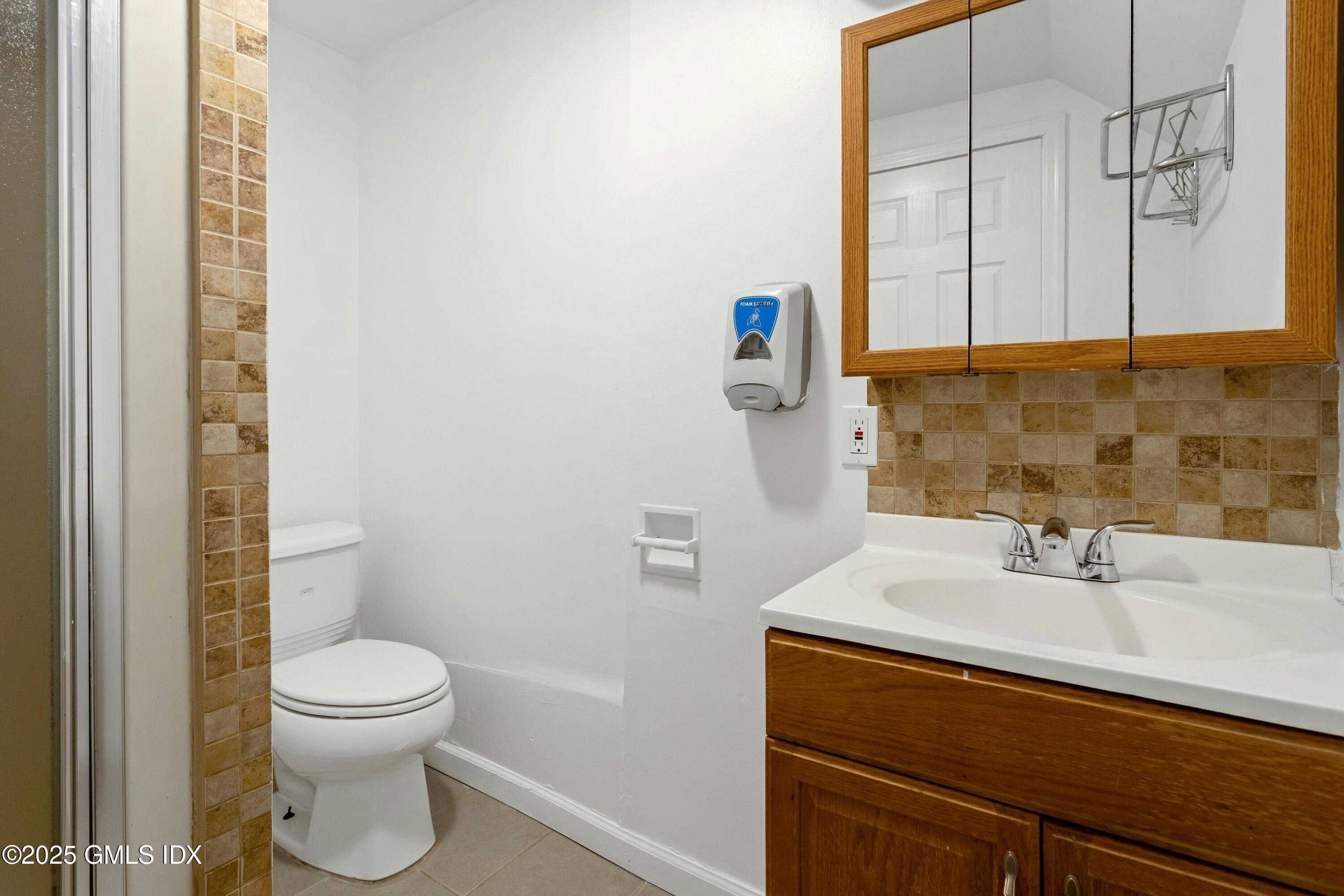 171 1/2 Henry Street, Unit A Greenwich, CT 06830 - Photo 15 of 25 a bathroom with a sink a toilet and a mirror
