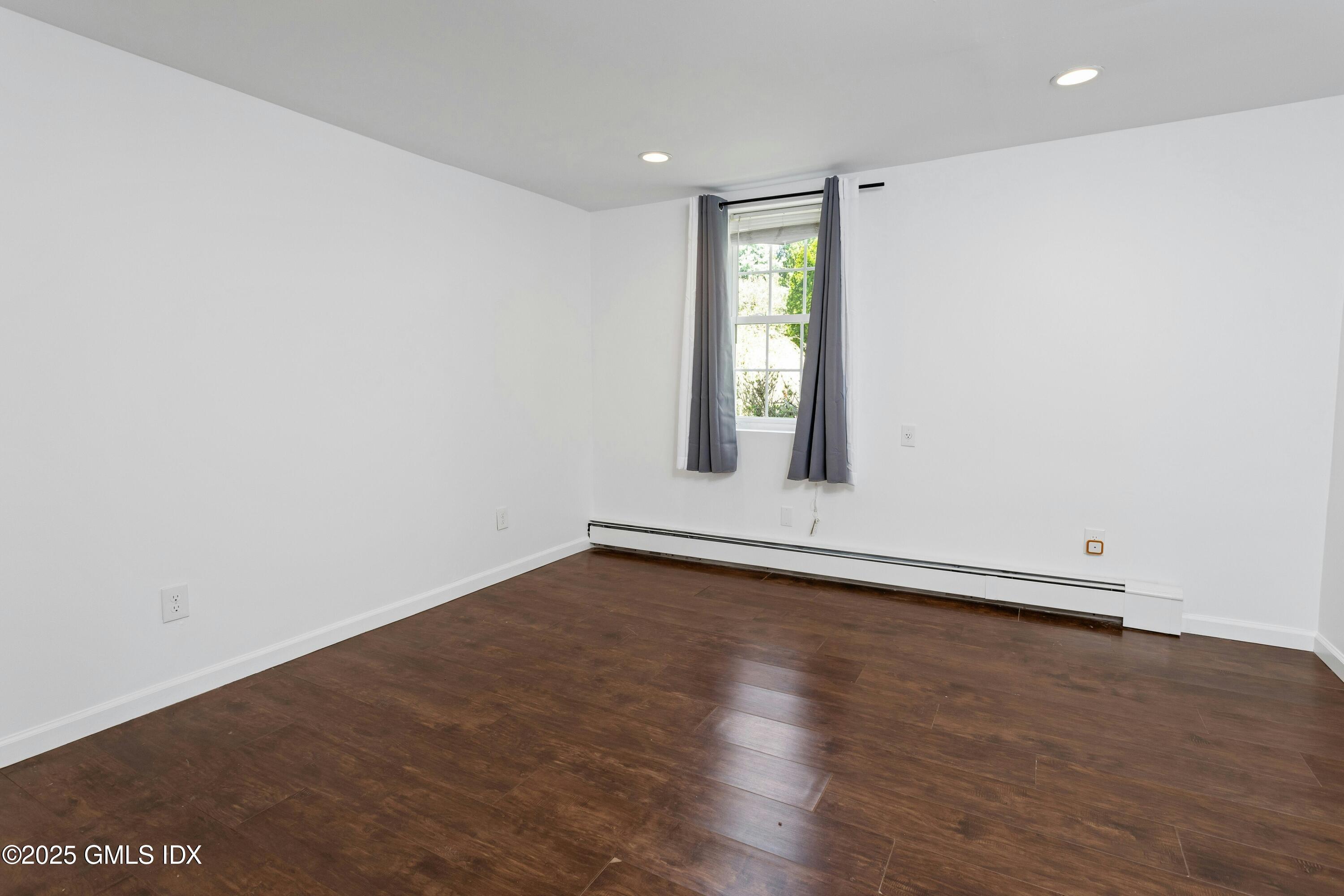 171 1/2 Henry Street, Unit A Greenwich, CT 06830 - Photo 17 of 25 an empty room with wooden floor and windows