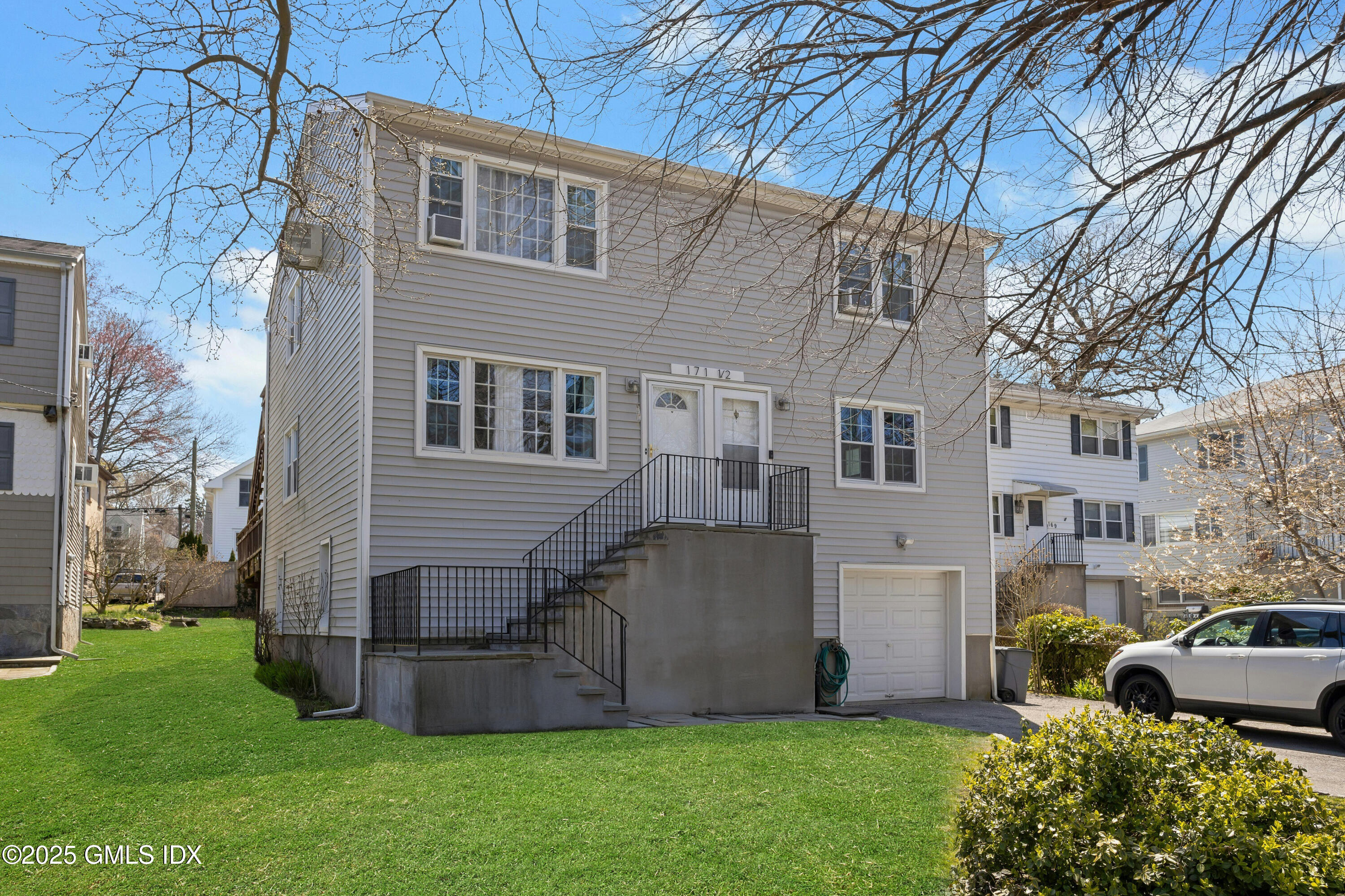 171 1/2 Henry Street, Unit A Greenwich, CT 06830 - Photo 2 of 25 a front view of a house with a garden