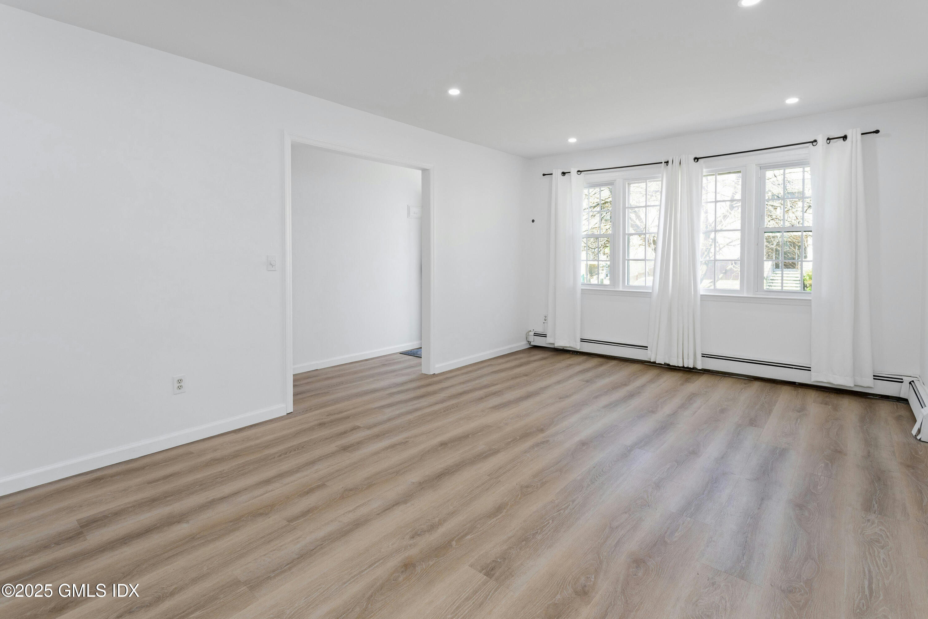171 1/2 Henry Street, Unit A Greenwich, CT 06830 - Photo 5 of 25 an empty room with wooden floor and windows