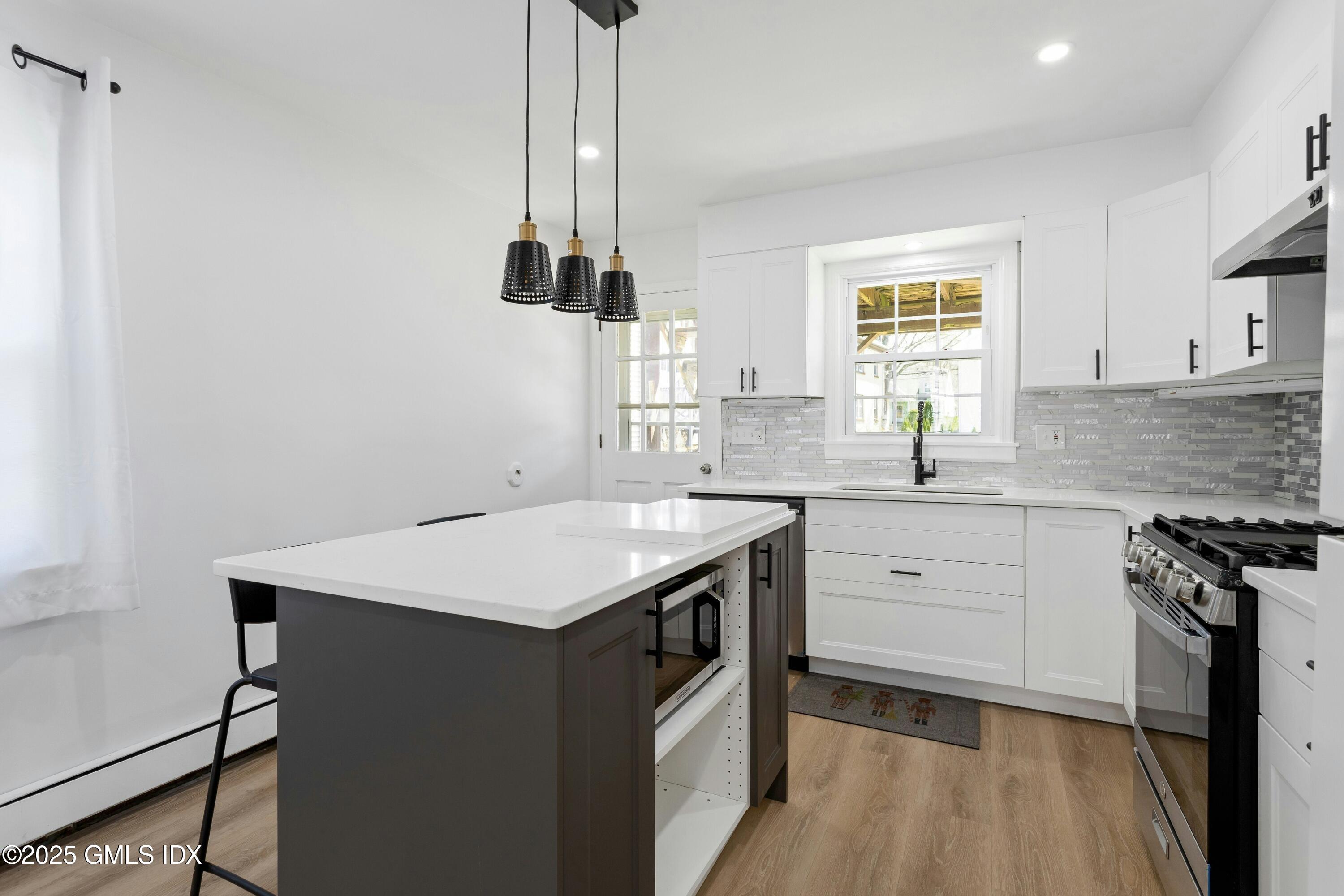 171 1/2 Henry Street, Unit A Greenwich, CT 06830 - Photo 7 of 25 a kitchen with a sink stove and cabinets