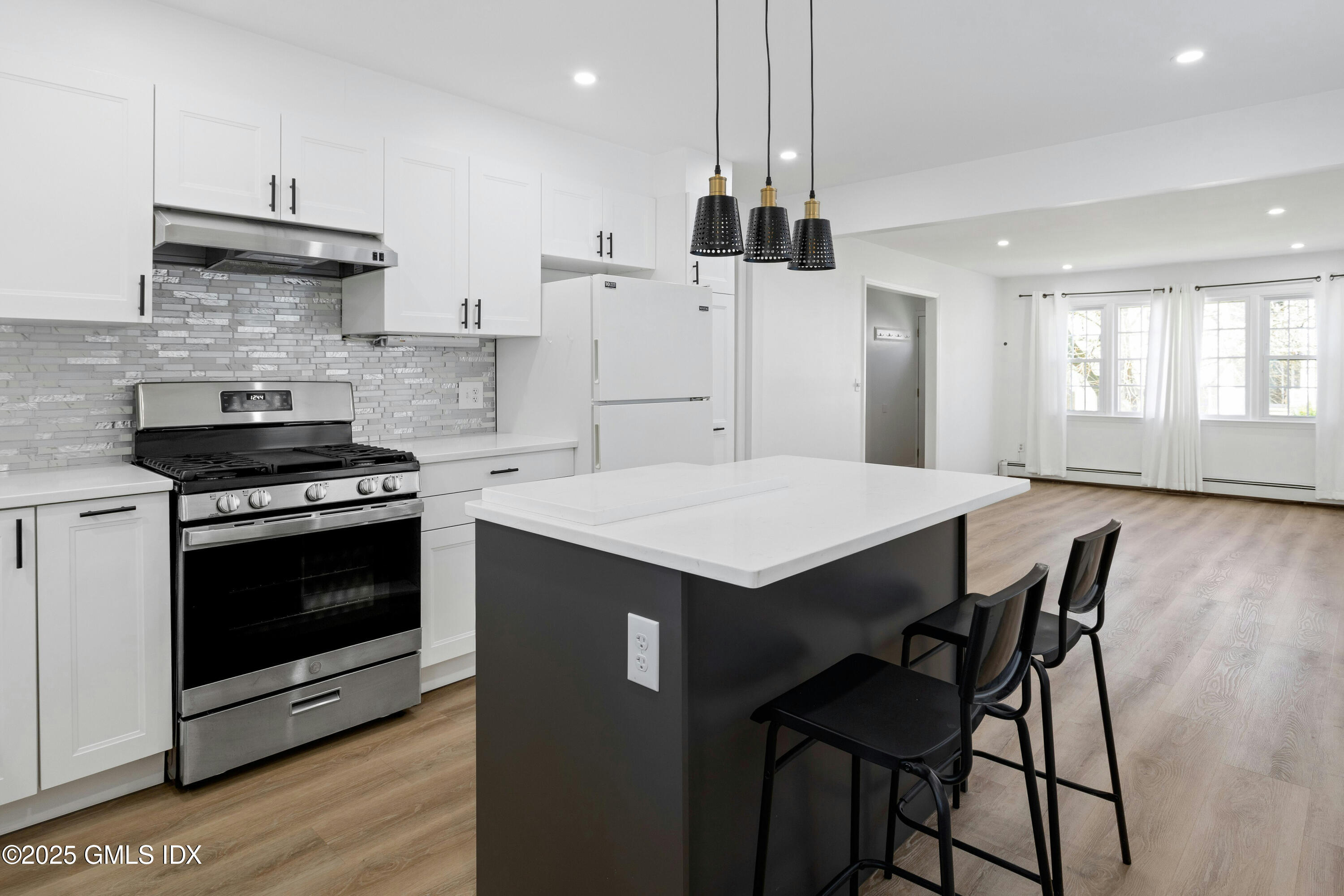 171 1/2 Henry Street, Unit A Greenwich, CT 06830 - Photo 8 of 25 a kitchen with a stove a refrigerator and a wooden floor