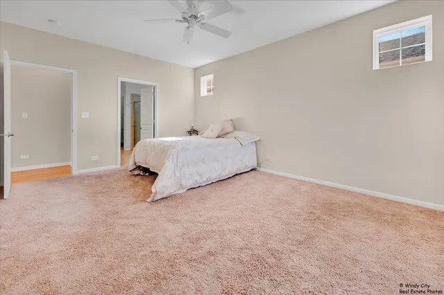 a spacious bedroom with a bed and a chandelier