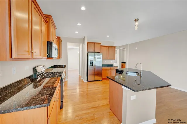 a kitchen with stainless steel appliances granite countertop a sink counter space and a stove top oven
