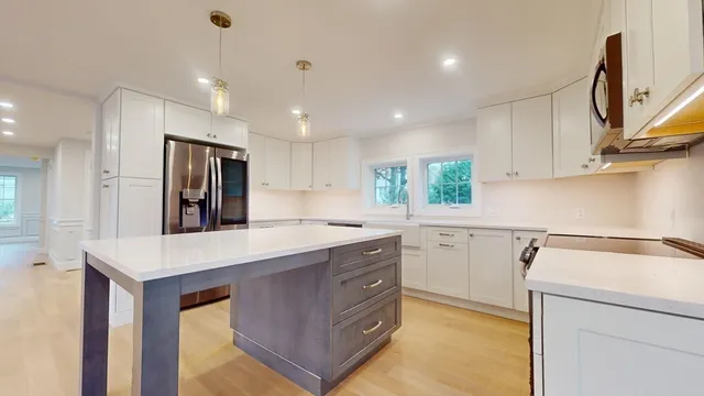 a kitchen with a sink a refrigerator and cabinets