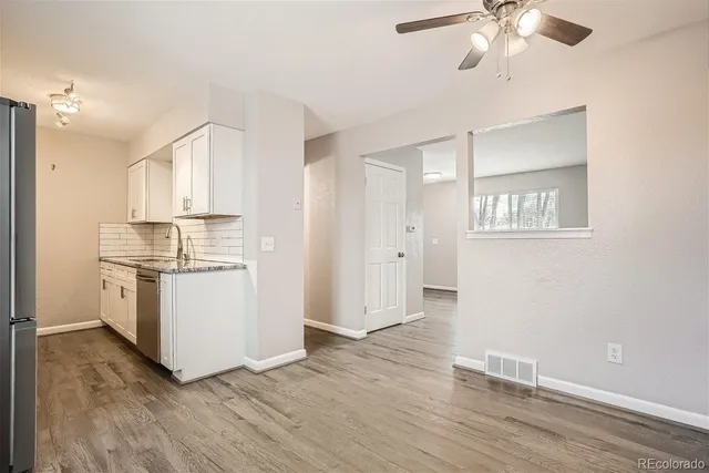 a kitchen with a refrigerator and white cabinets