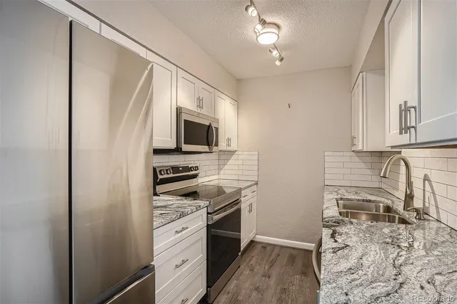a kitchen with stainless steel appliances a stove microwave and sink
