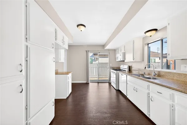a kitchen with stainless steel appliances white cabinets and wooden floors