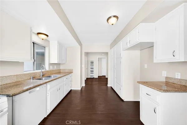 a view of a big room with wooden floor and windows