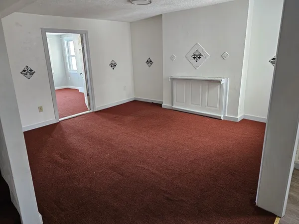 a view of an empty room with a fireplace