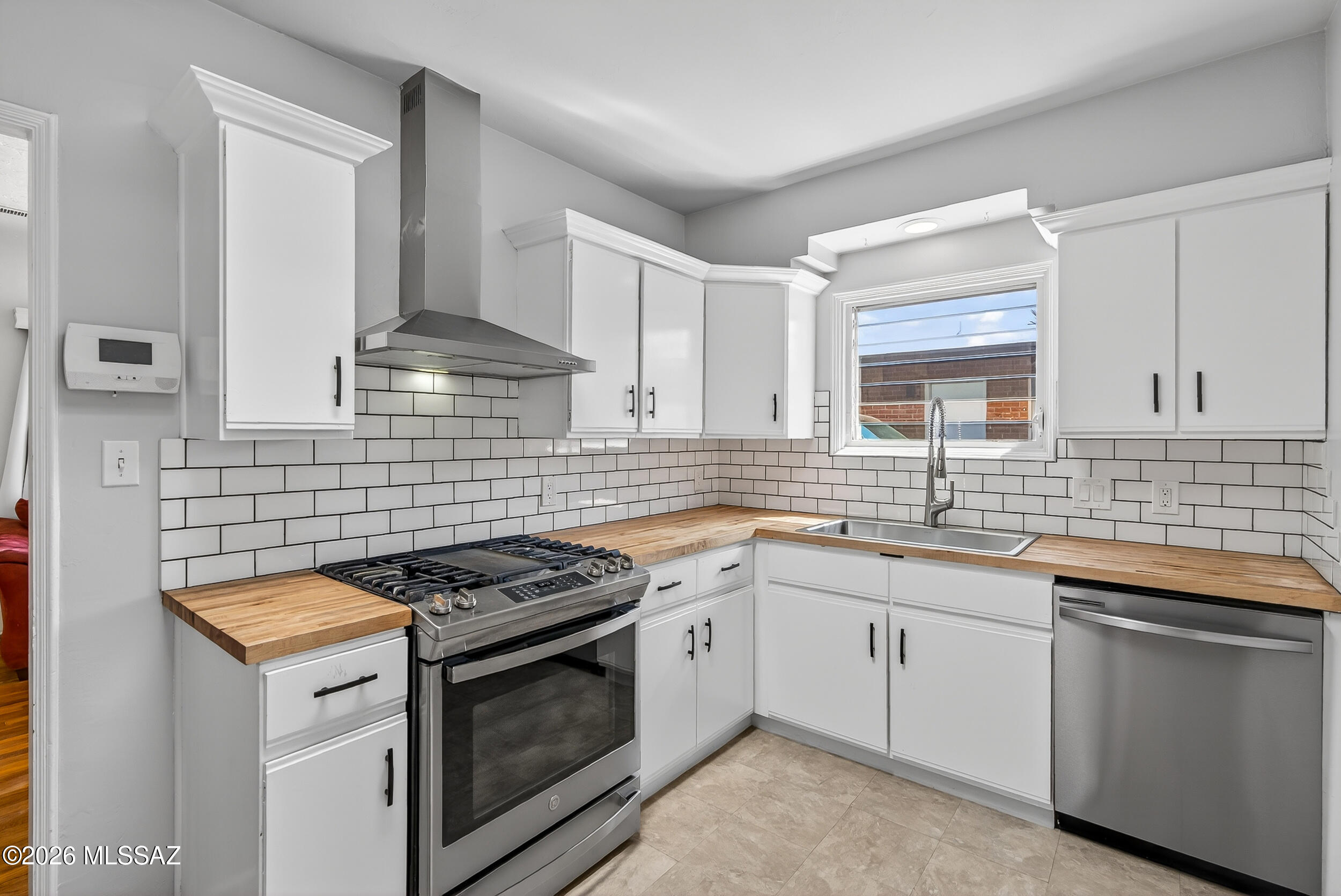 1412 East Spring Street Tucson, AZ 85719 - Photo 2 of 43 a kitchen with cabinets appliances a sink and a window