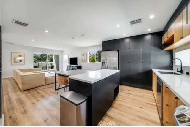 a kitchen with stainless steel appliances granite countertop a sink a stove and a refrigerator