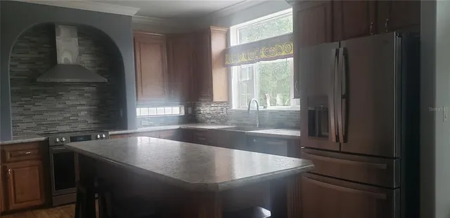 a kitchen with granite countertop stainless steel appliances refrigerator sink and cabinets