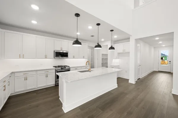 a kitchen with white cabinets and stainless steel appliances