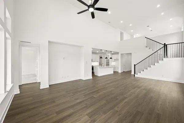 a view of empty room with wooden floor and windows
