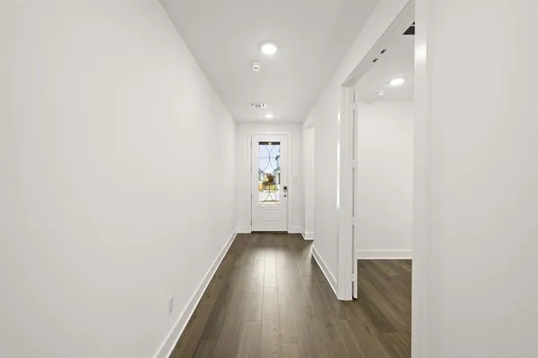 an empty room with wooden floor and entrance