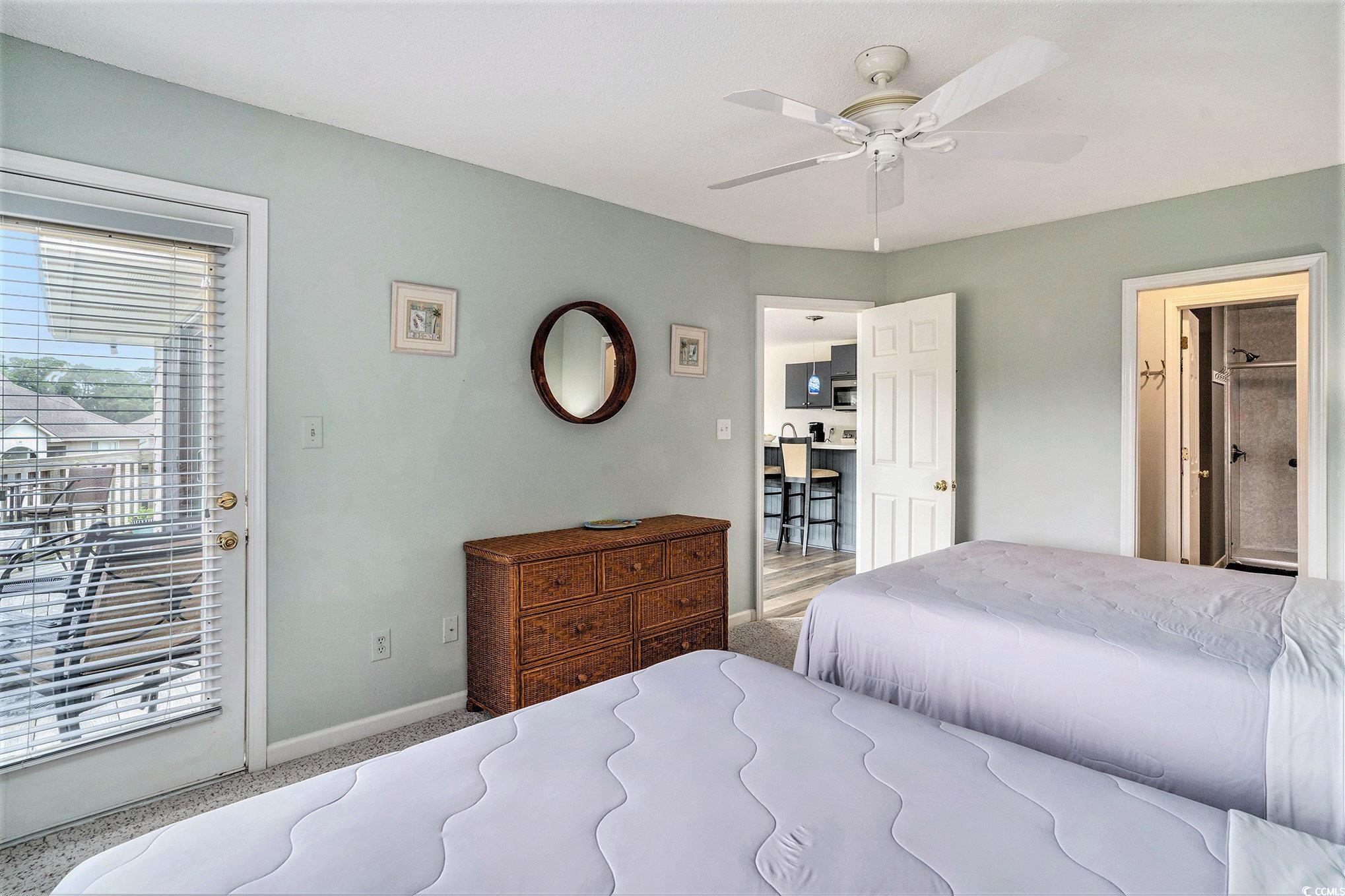815 Colony Place, Unit 15F Sunset Beach, NC 28468 - Photo 11 of 34 Bedroom featuring carpet floors, access to outside, ensuite bath, and ceiling fan