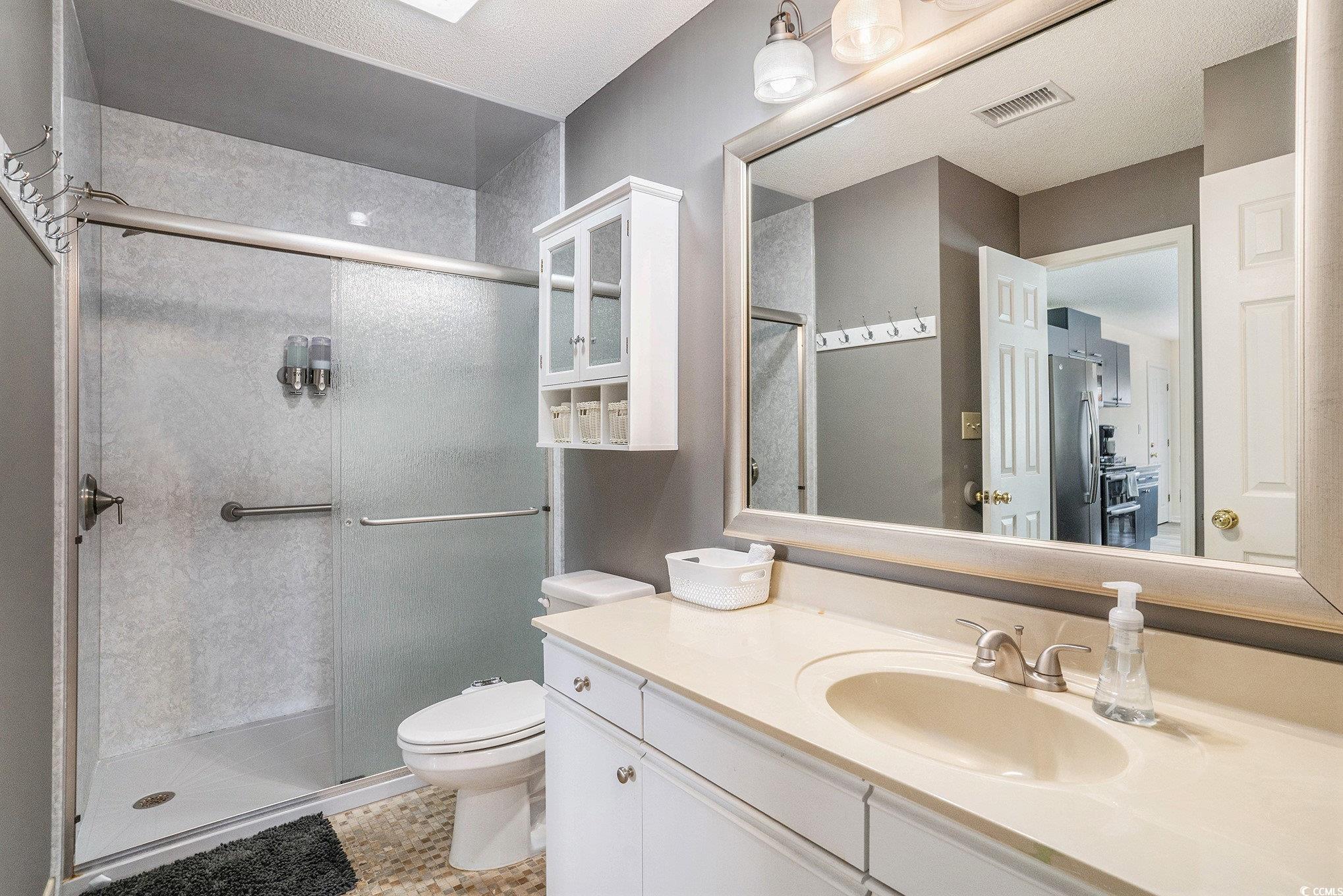 815 Colony Place, Unit 15F Sunset Beach, NC 28468 - Photo 16 of 34 Full bath featuring a shower stall, vanity, and light tile patterned floors