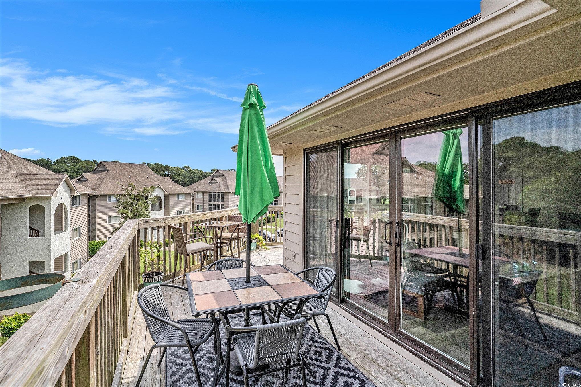 815 Colony Place, Unit 15F Sunset Beach, NC 28468 - Photo 20 of 34 Wooden deck featuring a residential view and outdoor dining space