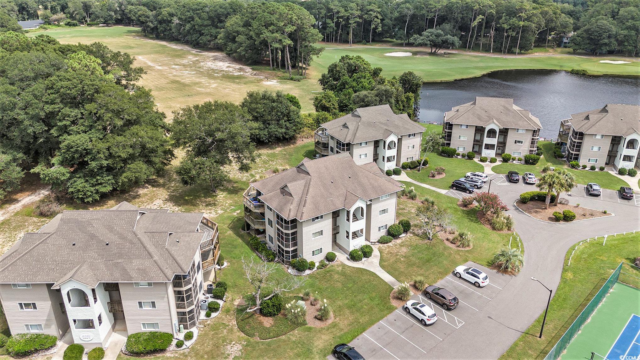 815 Colony Place, Unit 15F Sunset Beach, NC 28468 - Photo 24 of 34 Drone / aerial view of a golf course and a nearby body of water