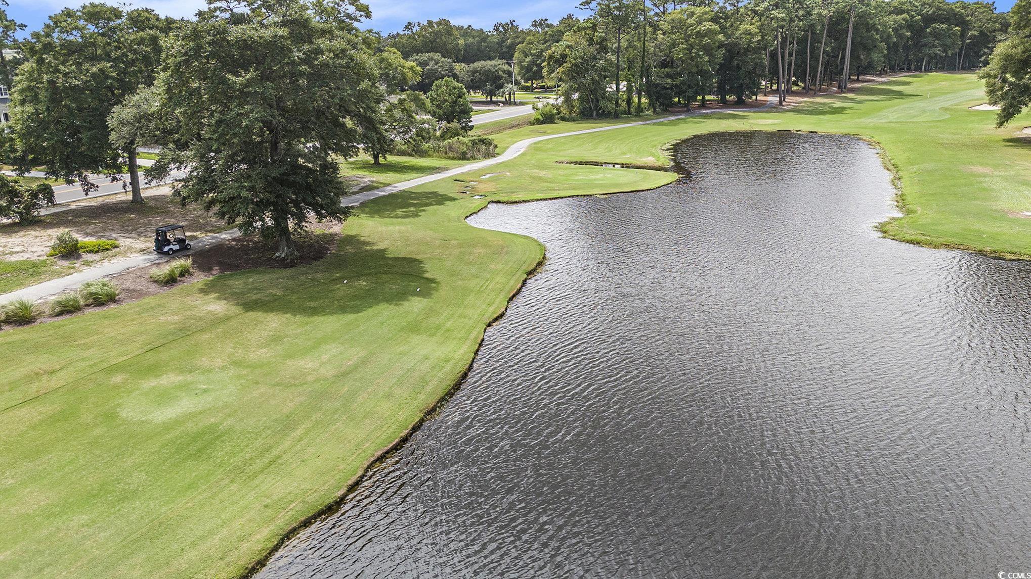 815 Colony Place, Unit 15F Sunset Beach, NC 28468 - Photo 27 of 34 View of community featuring golf course view, a water view, a lawn, and view of wooded area