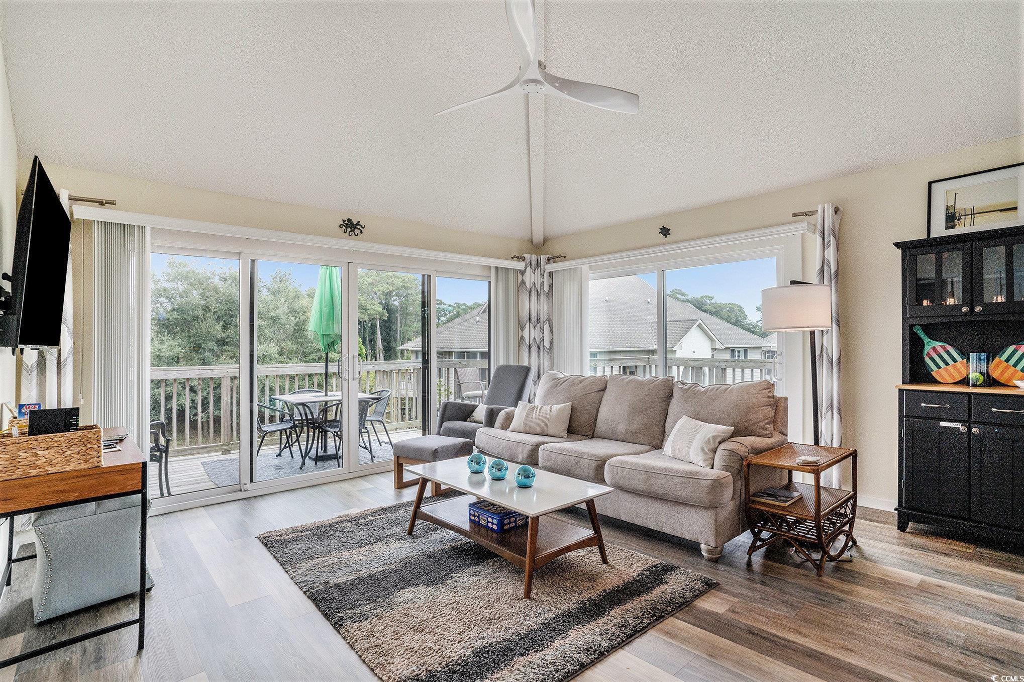 815 Colony Place, Unit 15F Sunset Beach, NC 28468 - Photo 3 of 34 Living area featuring light wood-type flooring, vaulted ceiling, and ceiling fan