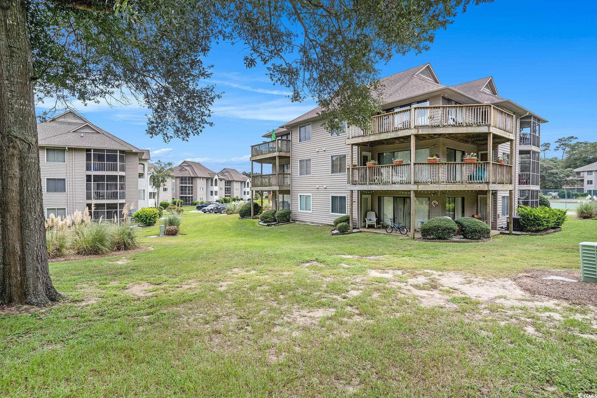 815 Colony Place, Unit 15F Sunset Beach, NC 28468 - Photo 31 of 34 View of property's community featuring a lawn, a residential view, and a balcony