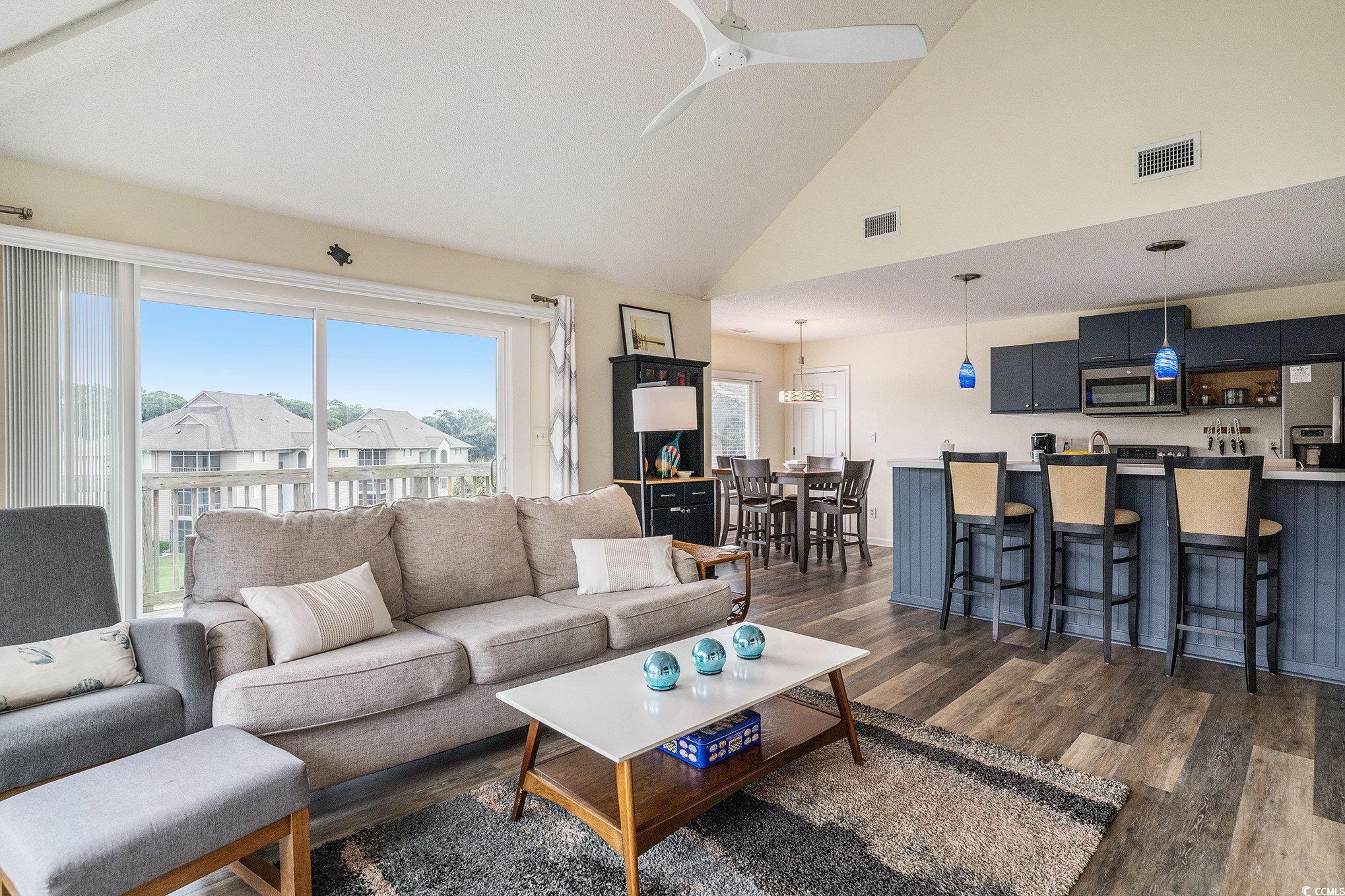 815 Colony Place, Unit 15F Sunset Beach, NC 28468 - Photo 5 of 34 Living area with dark wood-style flooring, high vaulted ceiling, and ceiling fan