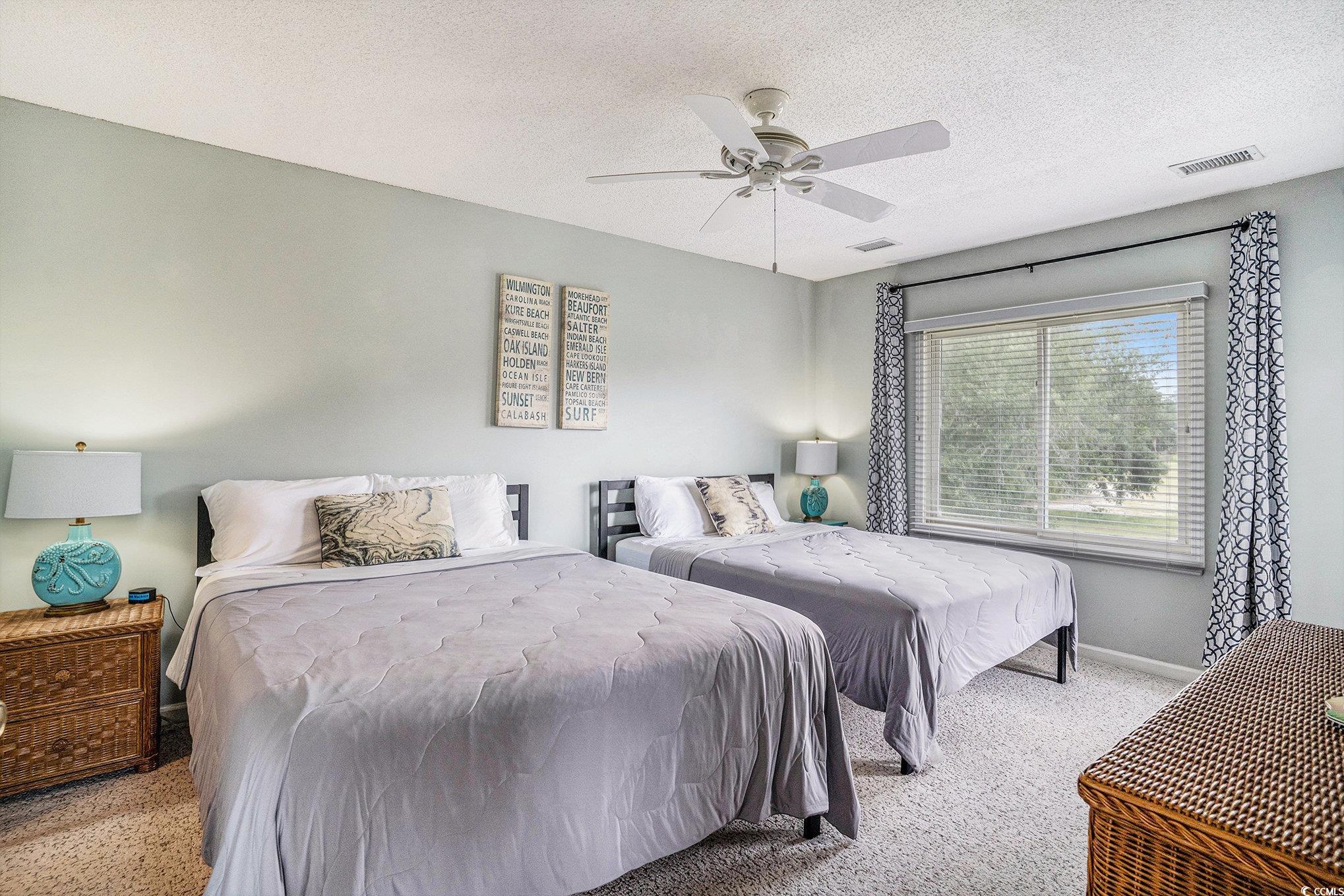 815 Colony Place, Unit 15F Sunset Beach, NC 28468 - Photo 10 of 34 Carpeted bedroom with a textured ceiling and a ceiling fan