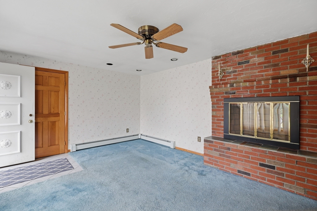 10 Deluca Road Milford, MA 01757 - Photo 6 of 37 a view of an empty room with a fireplace and a window